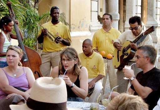 Jorge, junto a otros colegas, amenizan la estancia de un grupo de turistas en un restaurante de La Habana Vieja. MIAMI HERALD STAFF 