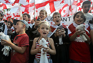Un grupo de niños con palomas y banderas de Georgia, en una protesta en Karaleti, frente a un puesto de control ruso. (Foto: AP)