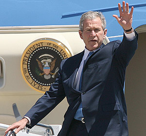 Bush saluda desde el avión presidencial a su llegada al aeropuerto de Waco, Texas. (Foto: AP)