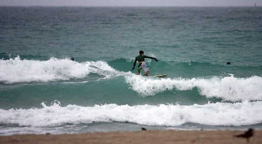 Surfistas aprovechan las olas que ocasionan los vientos de la tormenta tropical Fay. DAVID SANTIAGO/El Nuevo Herald 