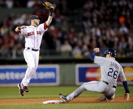 El jugador de los Rays de Tampa Bay Gabe Gross (d) roba la segunda base a pesar del intento de Dustin Pedroia (i), de los Medias Rojas de Boston, durante el partido por el campeonato de la Liga Americana de la MLB que se juega hoy, 16 de octubre de 2008, en el Fenway Park de Boston, Massachusetts (EEUU). Los Rays lideran la serie 3-1. EFE/MATT CAMPBELL 