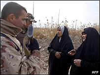Mujeres iraquíes conversan con soldados estadounidenses