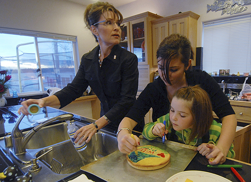 Alaska Gov. Sarah Palin mixes baby formula as her daughters Willow, 14, and Piper, 7, decorate a cake in the kitchen of their Wasilla, Alaska, home on Sunday, Nov. 9, 2008. AP 