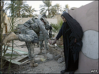 Soldado estadounidense recibe ayuda de una mujer iraquí