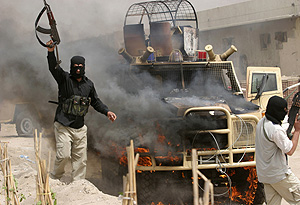 Varios guerrilleros celebran la quema de un vehículo. (Foto: AP | Nabil Al Jurani)