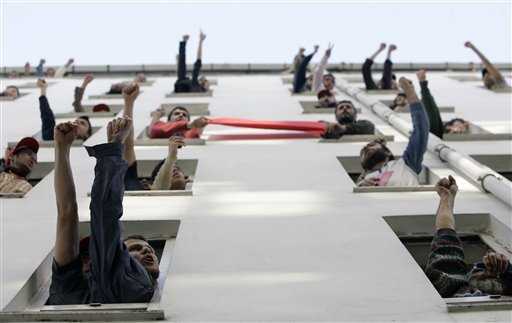 Trabajadores se refugiaron en edificios, desde donde corearon slogans contra la represión policial de la marcha del primero de mayo en Estanbul, Turquía. Ibrahim Usta / AP 