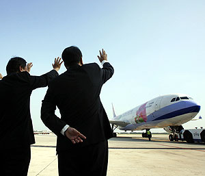 Las autoridades de Taiwán saludan la llegada del avión a su aeropuerto. (Foto: REUTERS)