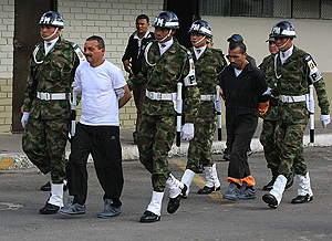 Gerardo Aguilar (segundo izq.) y Enrique Rojas (segundo der.) son escoltados por soldados colombianos en una base militar de Bogotá. AP 